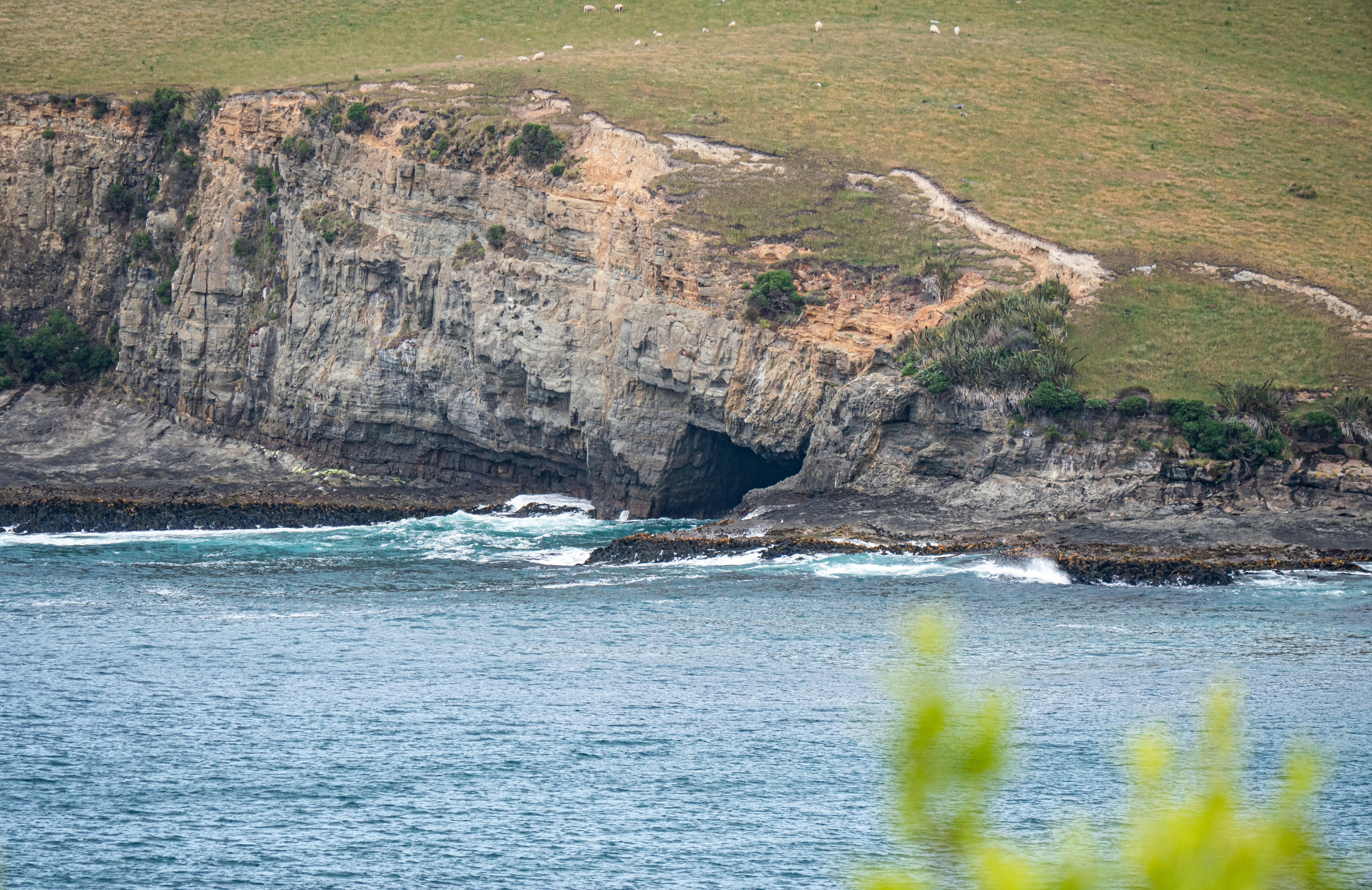 a large body of water with a cave in the middle of it, 