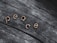 Wooden letters spelling out 'peace' are positioned on a textured, weathered wooden surface. The letters stand out with a light, warm color against the darker, grayish tones of the wood.