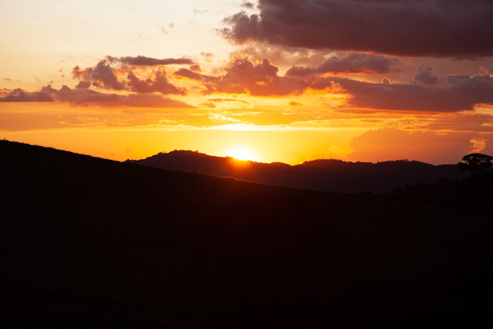 the sun is setting over a mountain range