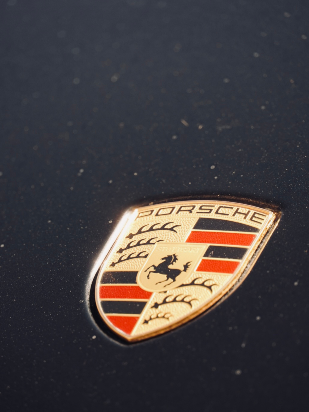 Gros plan d’un emblème Porsche sur une voiture