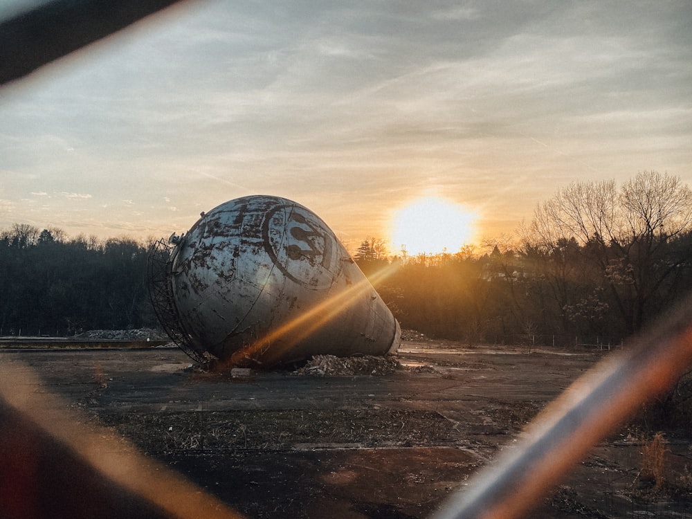 a large metal object sitting on top of a dirt field