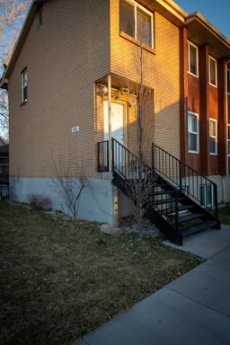 A welcoming front entrance of the Entrepreneurial Minds Academy building on Walnut Street, bathed in warm afternoon light.