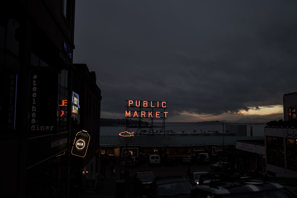 a public market sign lit up at night