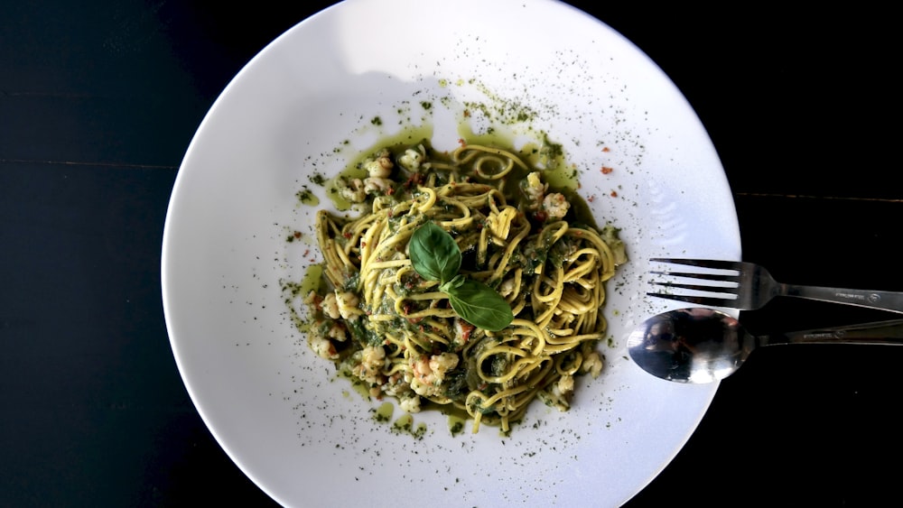 a white plate topped with pasta and pesto