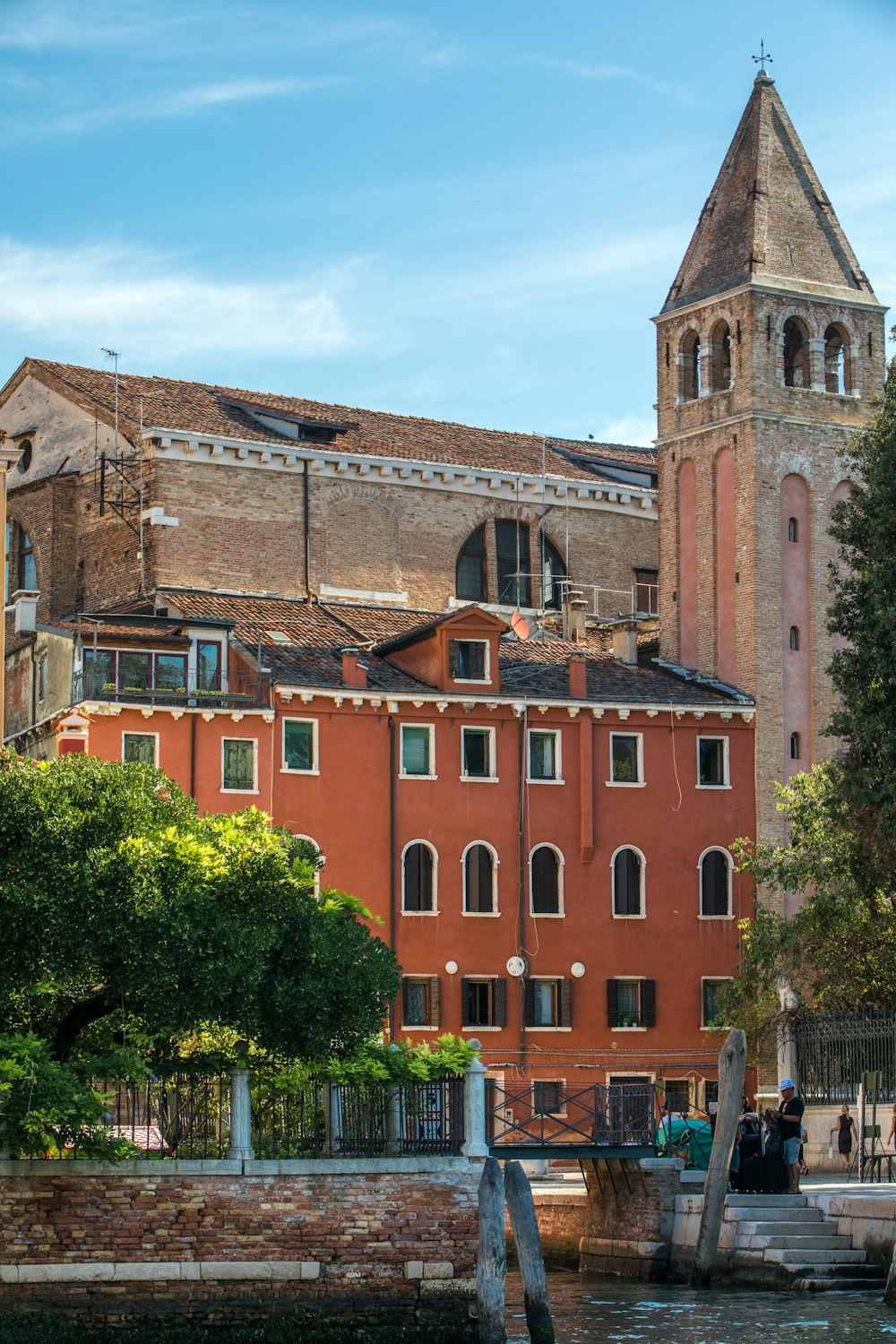 a large building with a clock tower next to a body of water