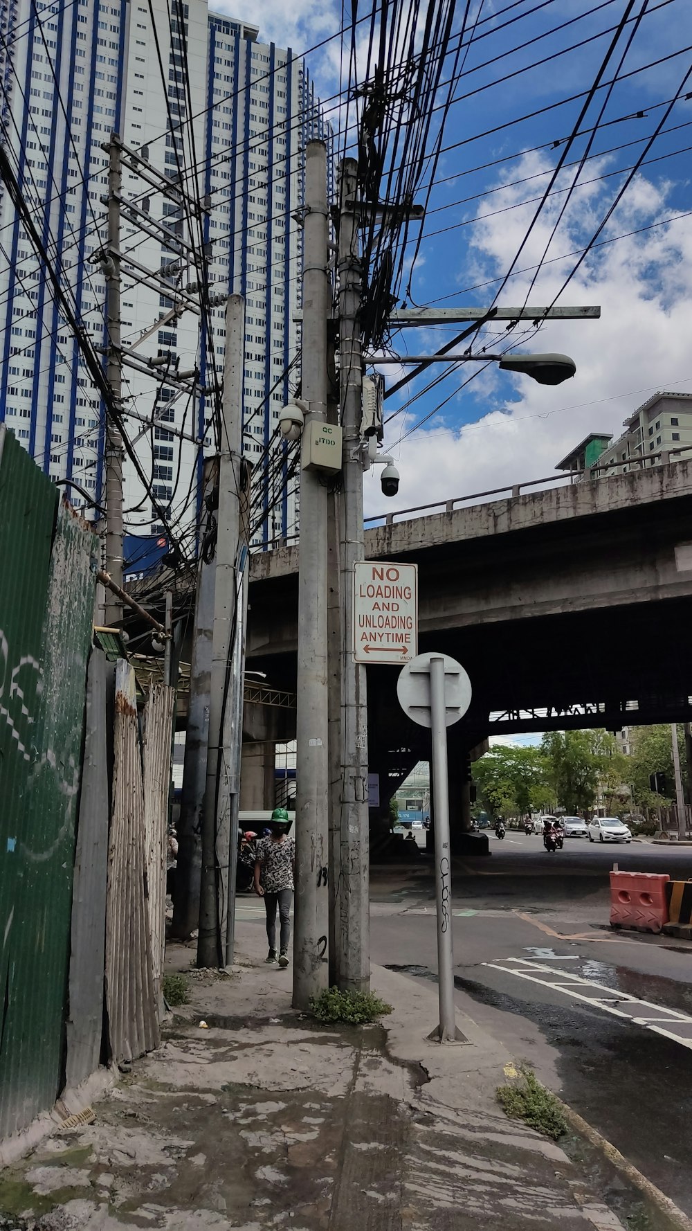 a man walking down a street next to a tall building