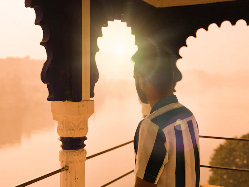 Indian sugar mama on a balcony overlooking serene waters