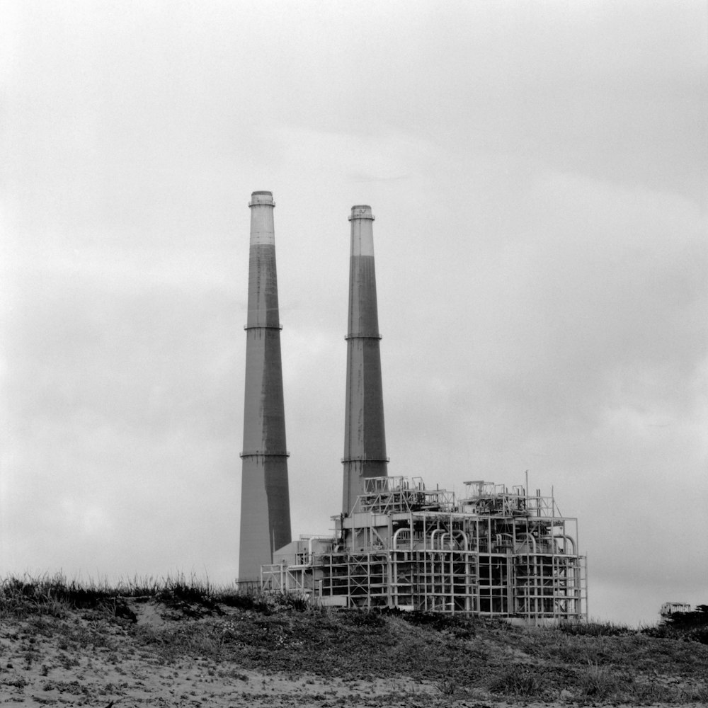 a black and white photo of two smoke stacks