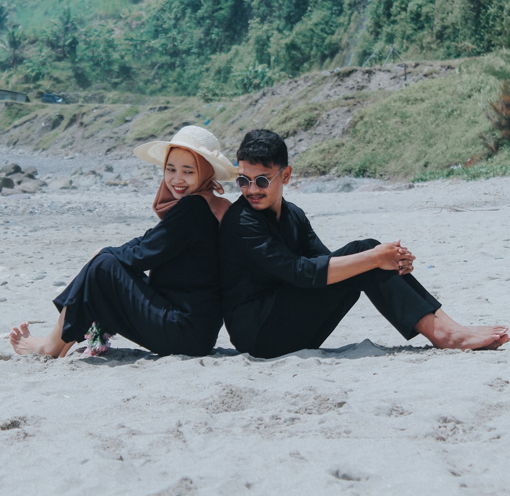 a man and a woman are sitting on the beach