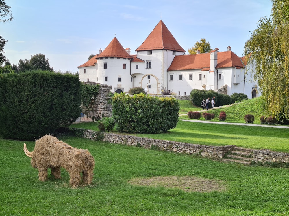 a wooly animal grazing in front of a castle