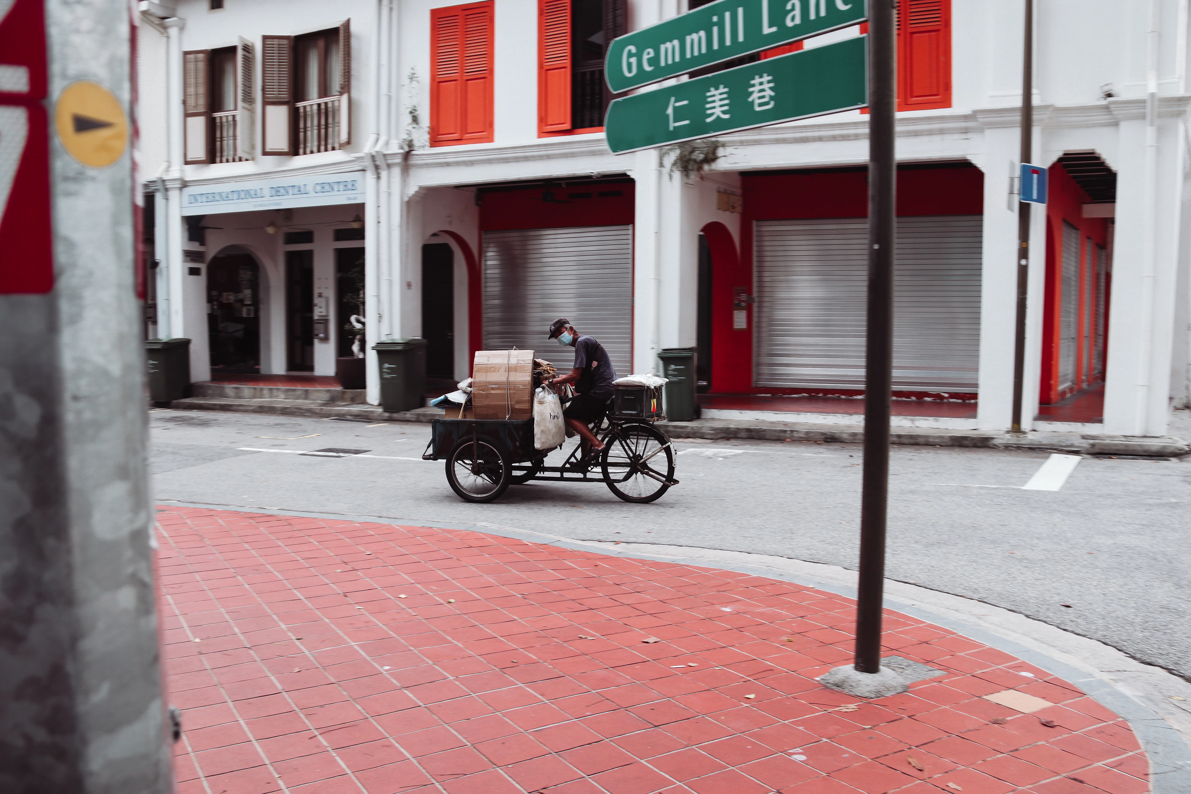 A cyclist pedals a cargo trishaw down the quiet red-brick pavement of Gemmill Lane in Chinatown.