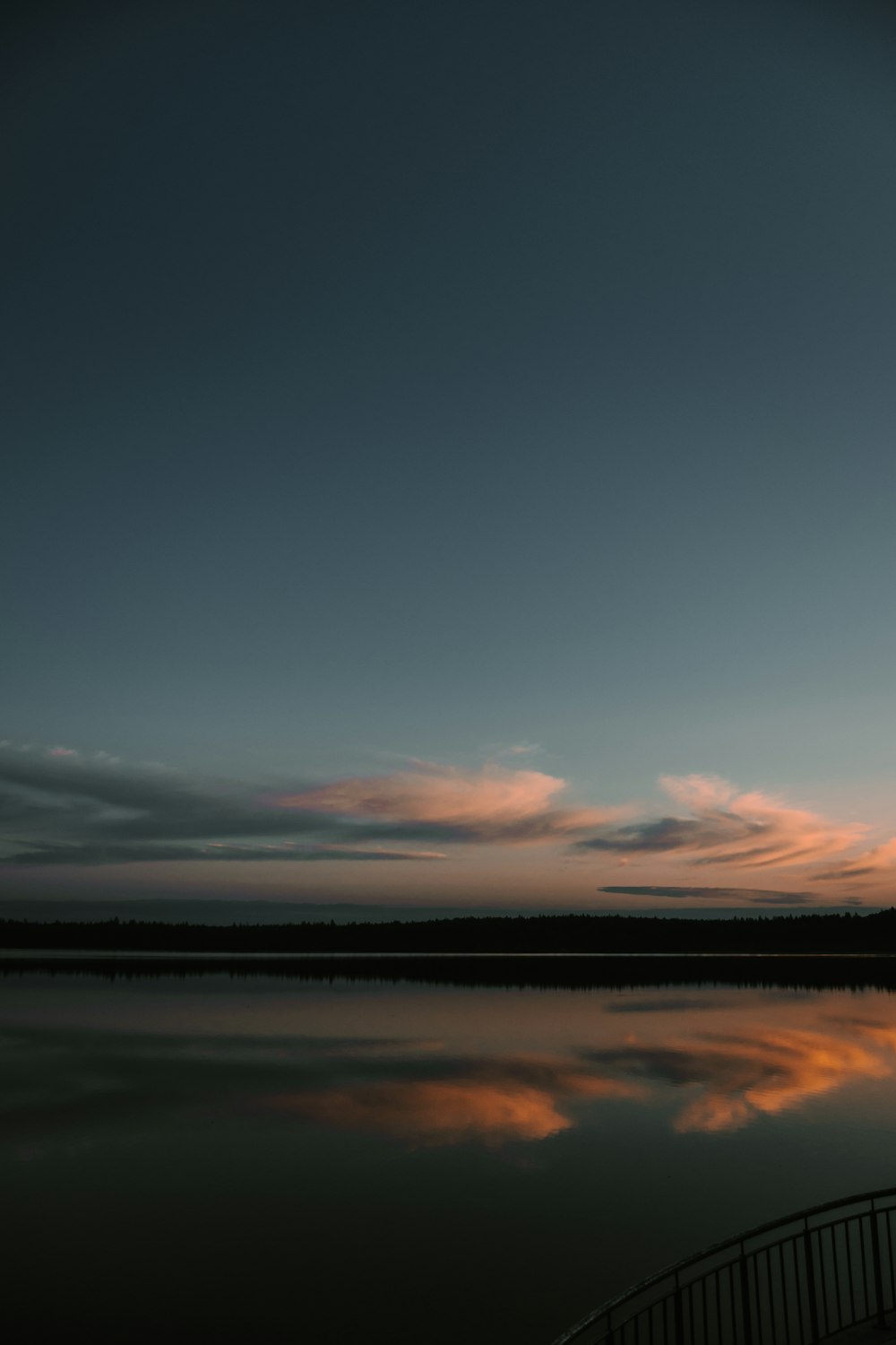 a person standing on a dock near a body of water