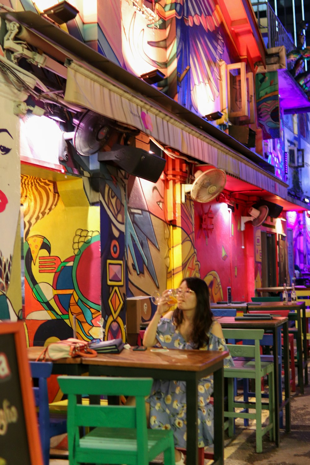 a woman sitting at a table in a brightly lit restaurant