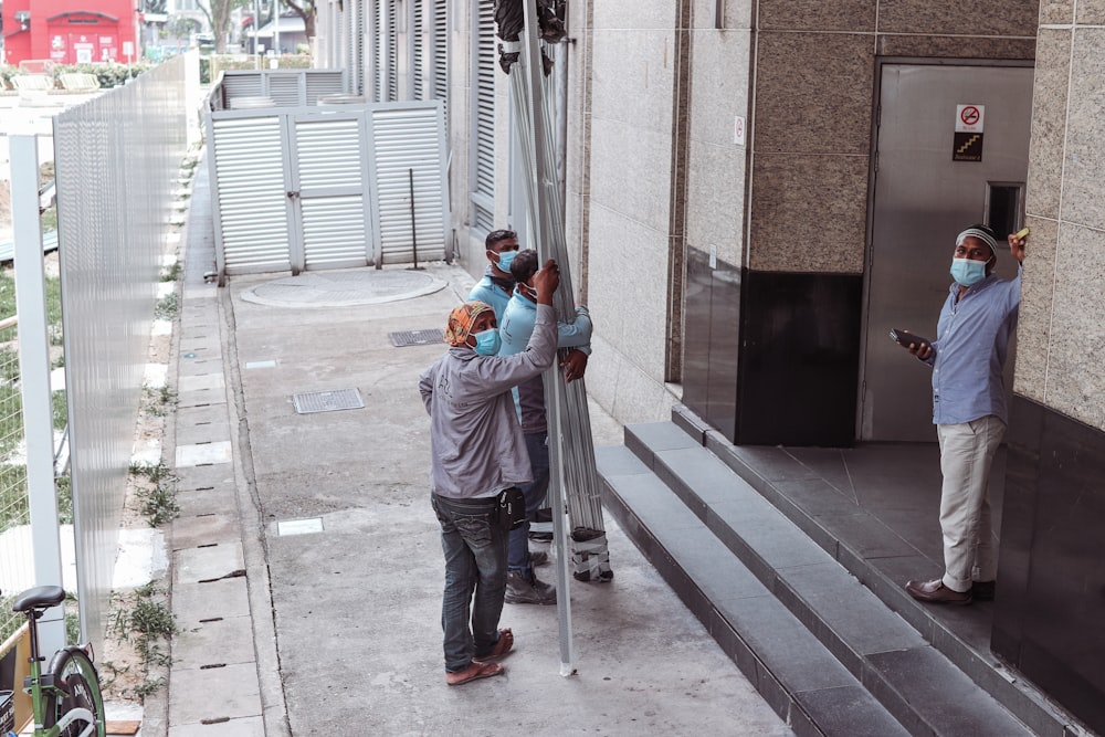 a group of people standing on the side of a building