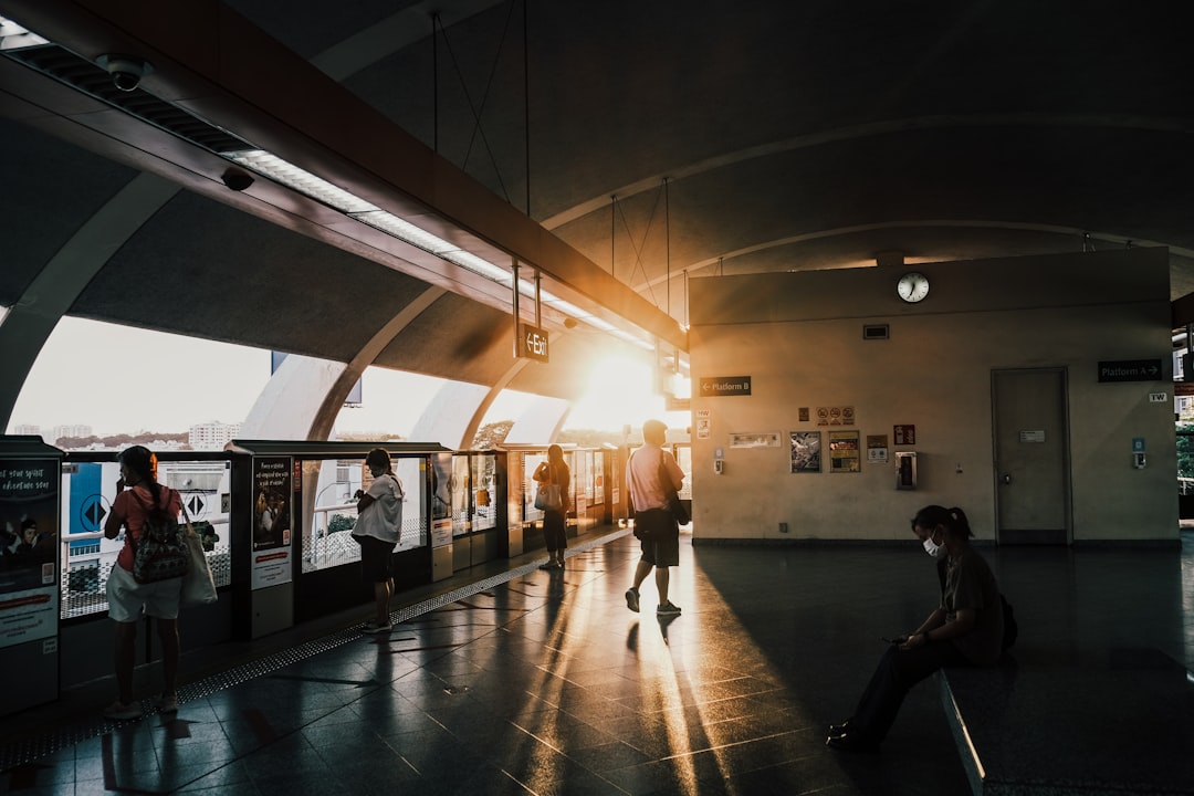 a group of people standing around a train station, Singapore Tampines MRT station open air view