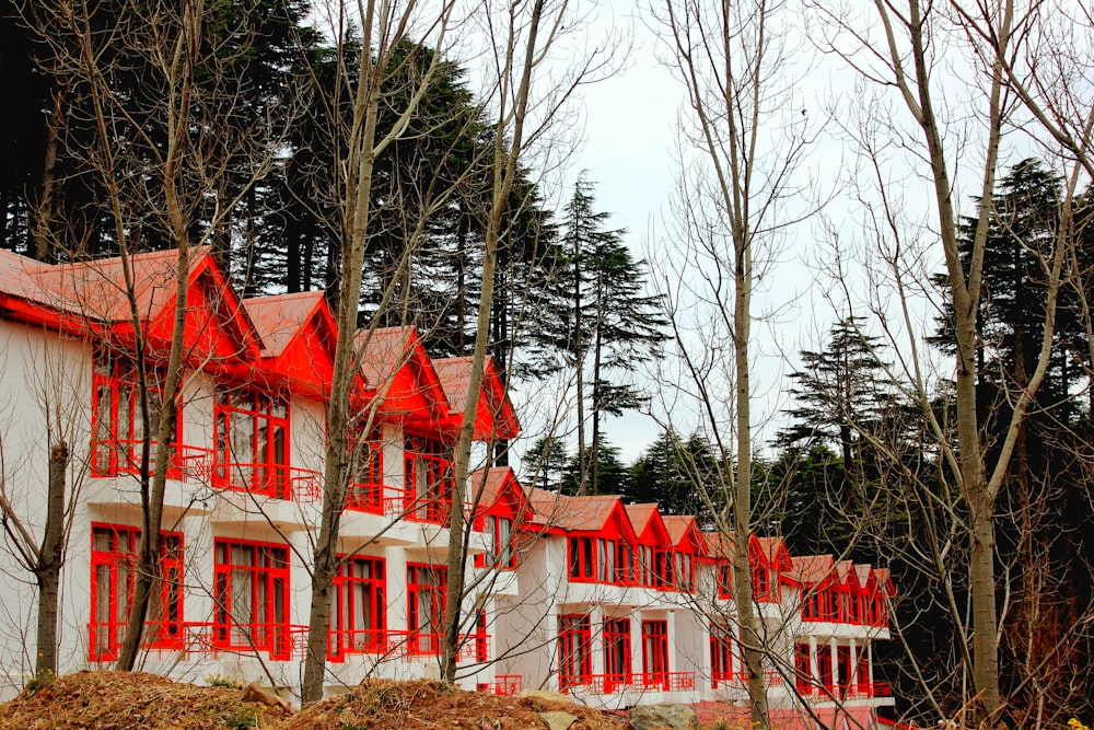 a row of red and white houses with trees in the background