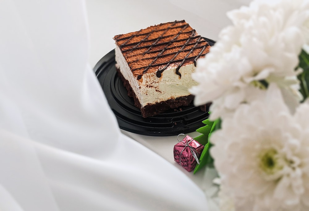 a piece of cake sitting on top of a black plate