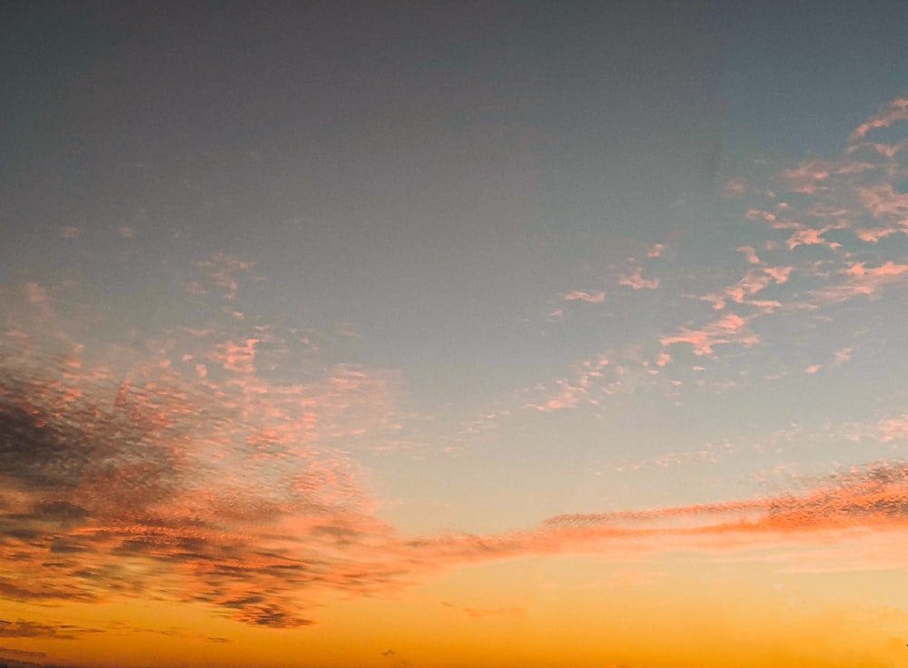 a plane flying in the sky at sunset