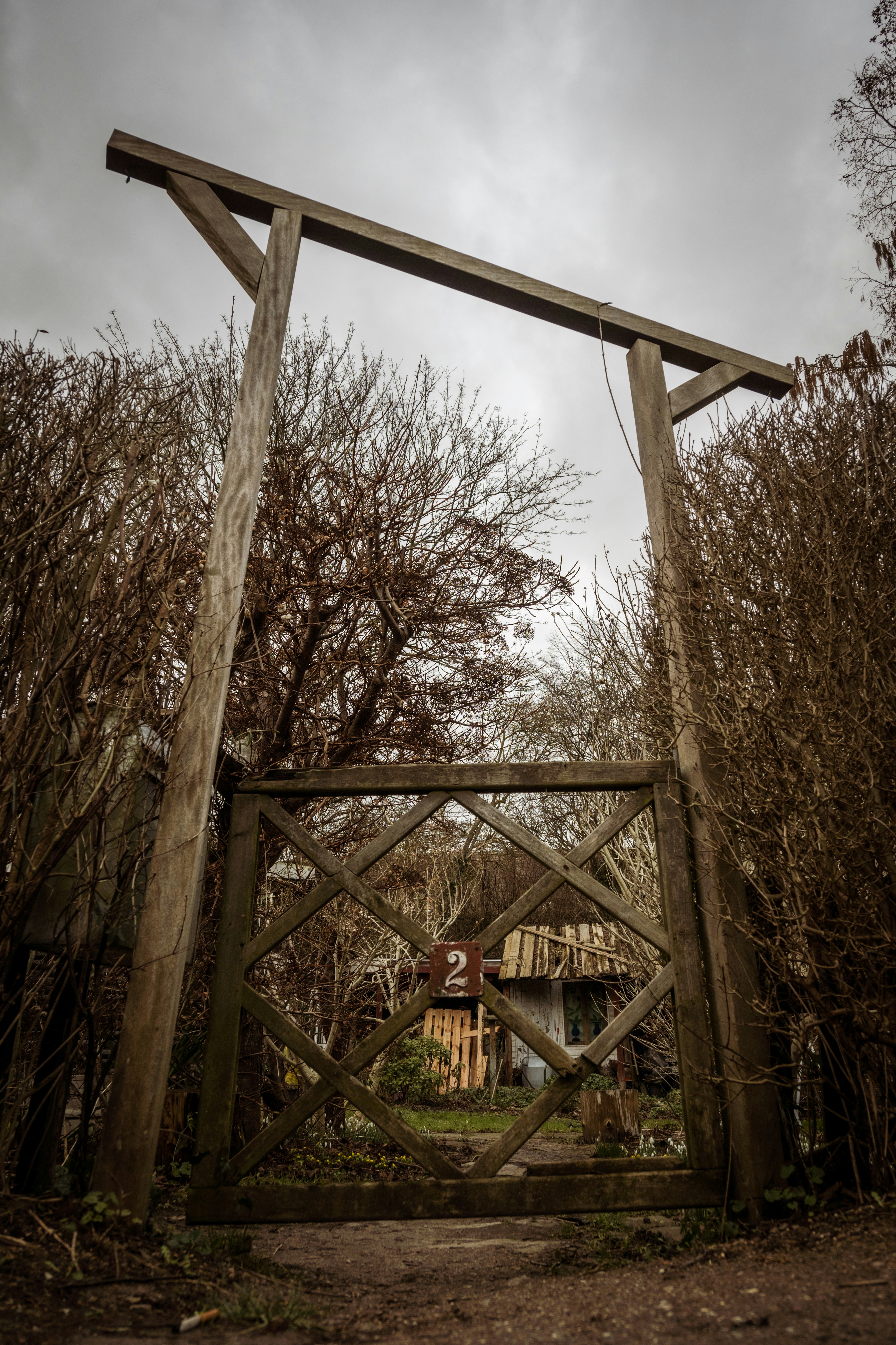a wooden gate with a house in the background