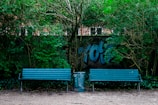 Urban stainless steel benches and trash bins installed in a public park.