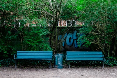 Urban stainless steel benches and trash bins installed in a public park.