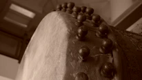 Close-up of skilled hands tuning a traditional drum, highlighting texture and craftsmanship.