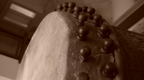 Close-up of a master craftsman hand-finishing a wooden drum shell in a warm workshop.