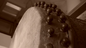 Close-up of a skilled artisan shaping the wooden frame of a mandar drum with traditional tools