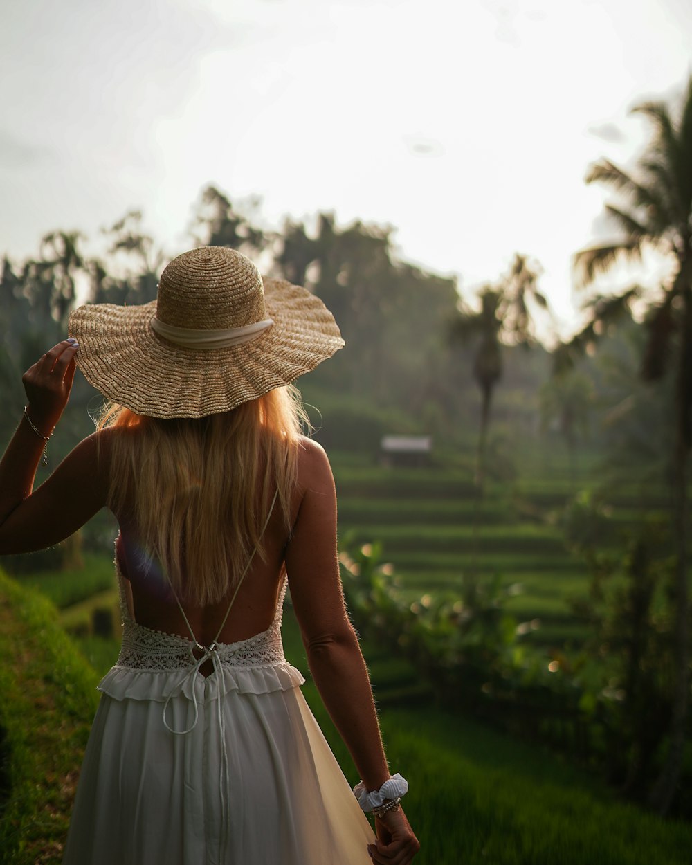 a woman in a white dress and a straw hat