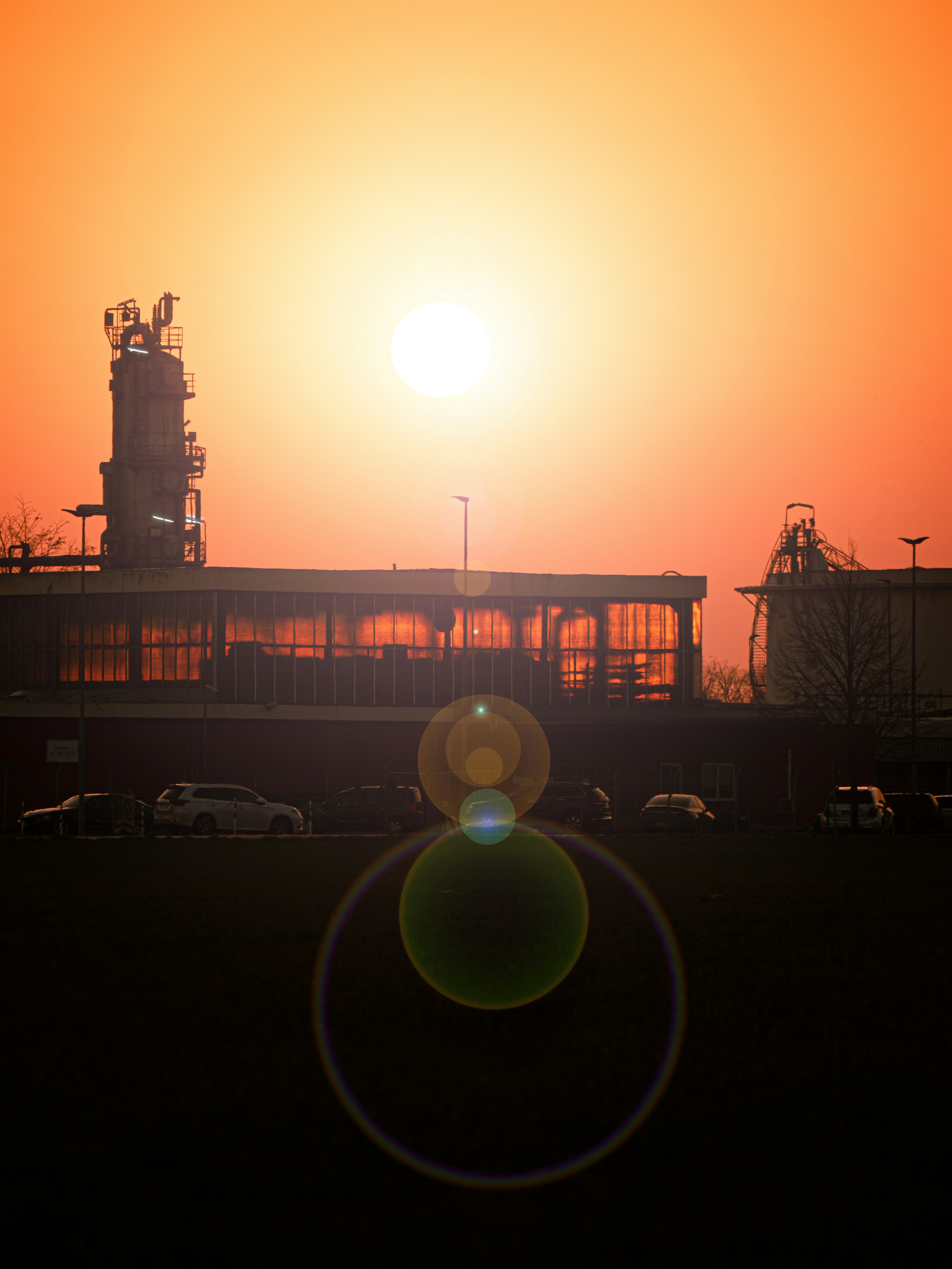 the sun is setting behind a large building