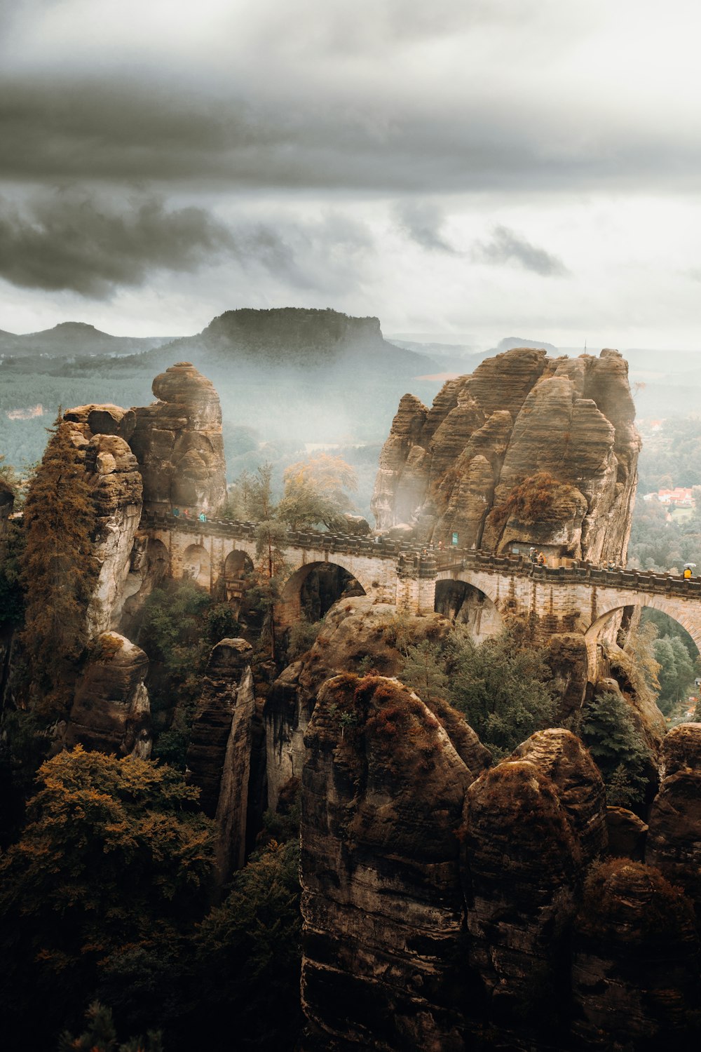 a train traveling over a bridge surrounded by mountains