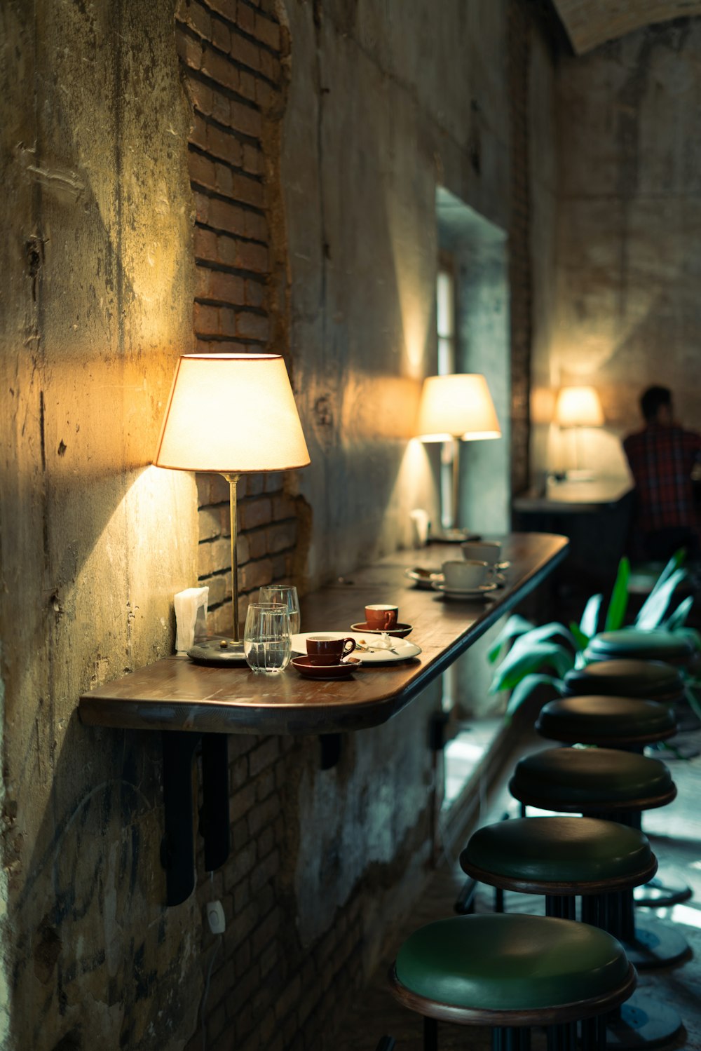 a row of bar stools sitting next to a brick wall