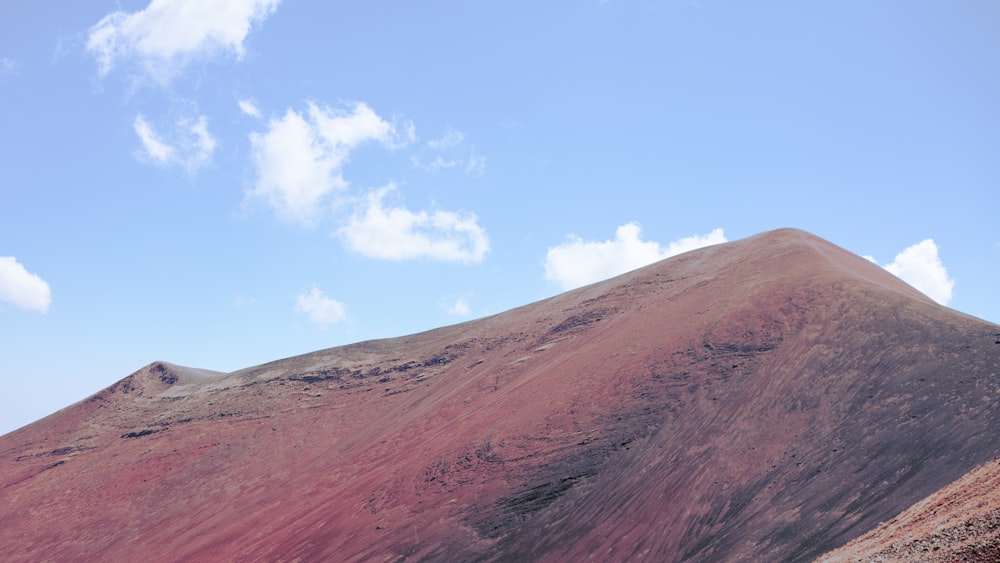 a mountain with a very tall red hill on it's side