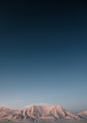 a snow covered mountain range under a blue sky
