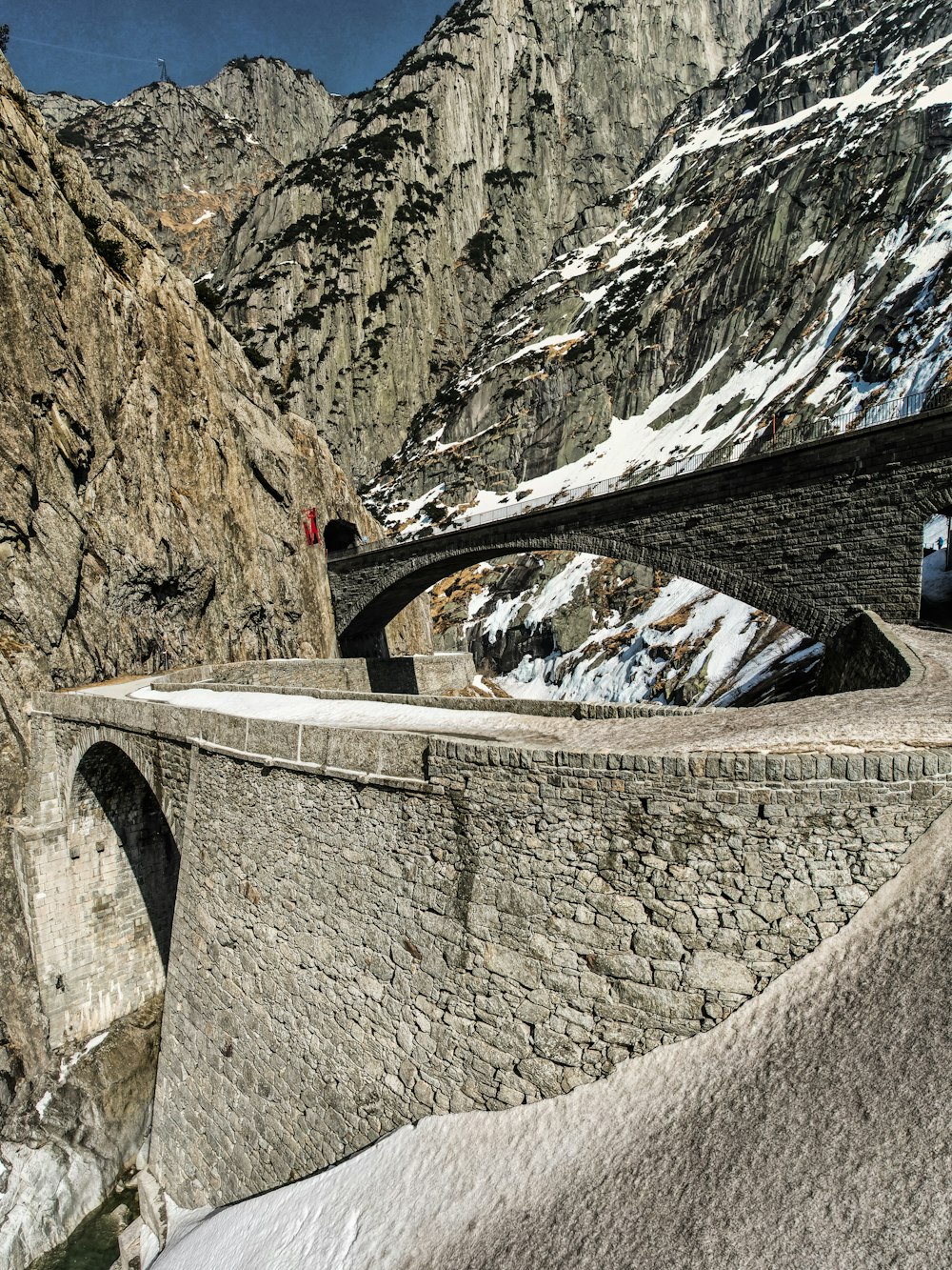 a car driving over a bridge in the mountains