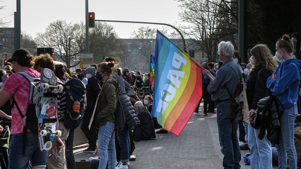 a group of people standing on a street next to a traffic light