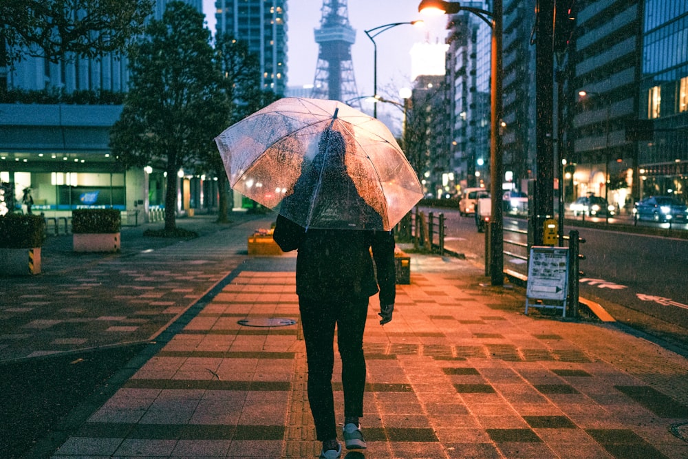 a person walking down a street holding an umbrella