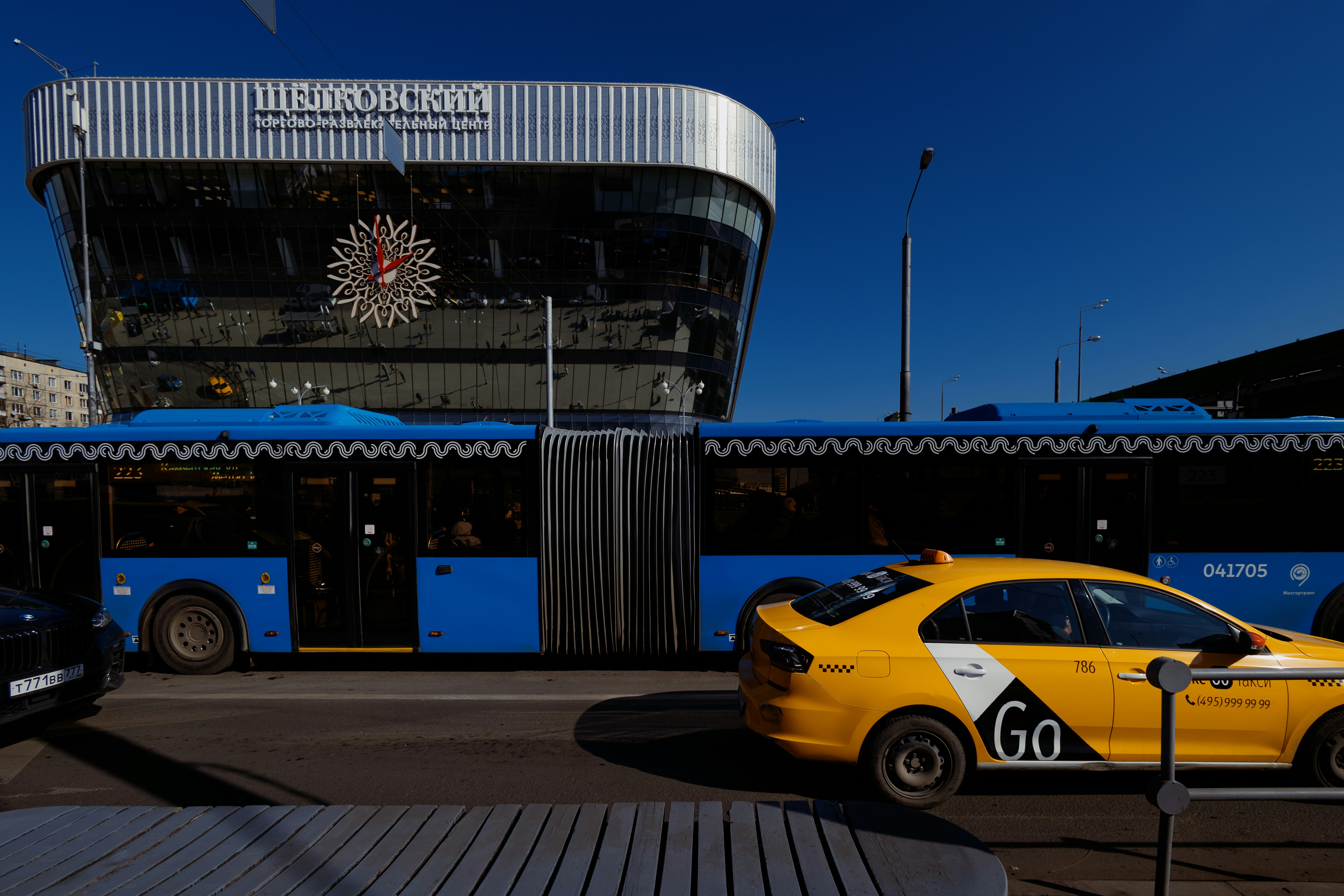 a yellow car parked in front of a bus stop