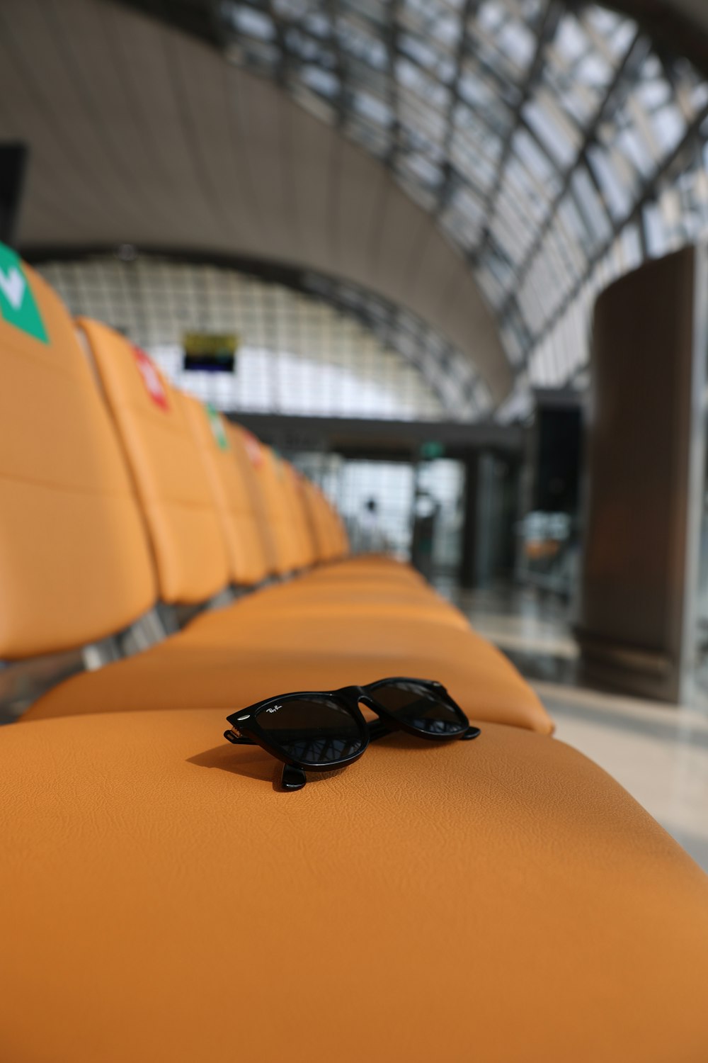 a pair of sunglasses sitting on a seat in an airport