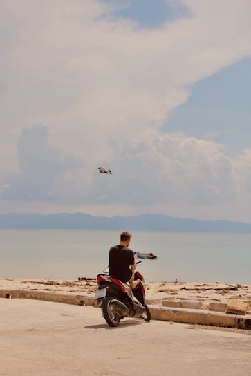 a man sitting on a motorcycle on the beach