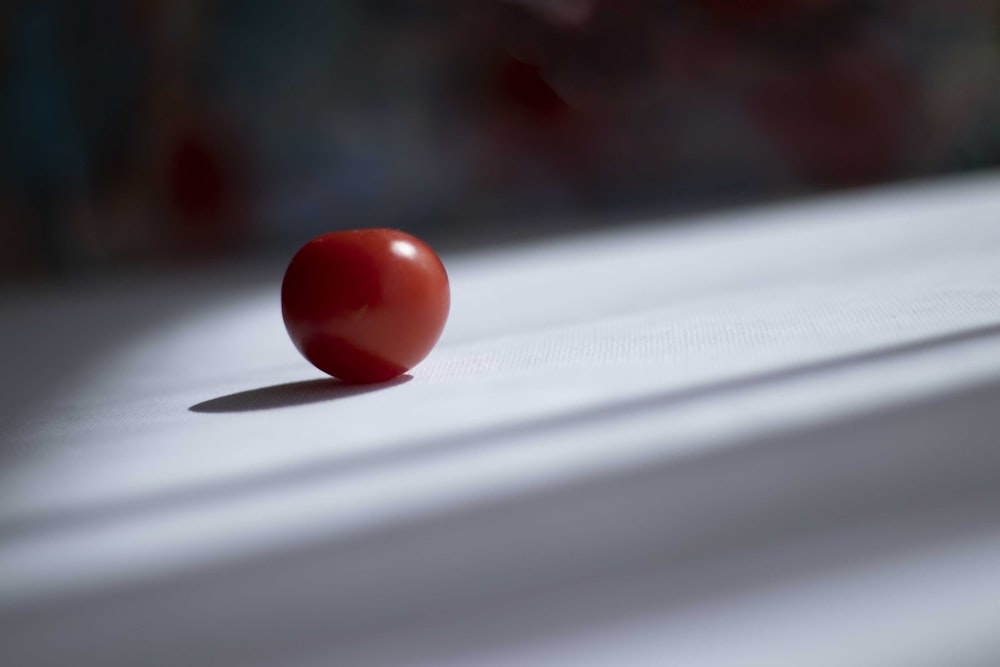 a single tomato sitting on top of a table