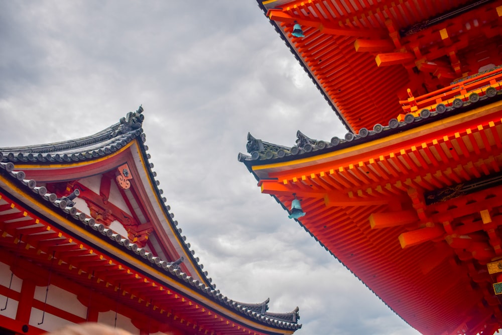 a couple of tall red buildings sitting under a cloudy sky