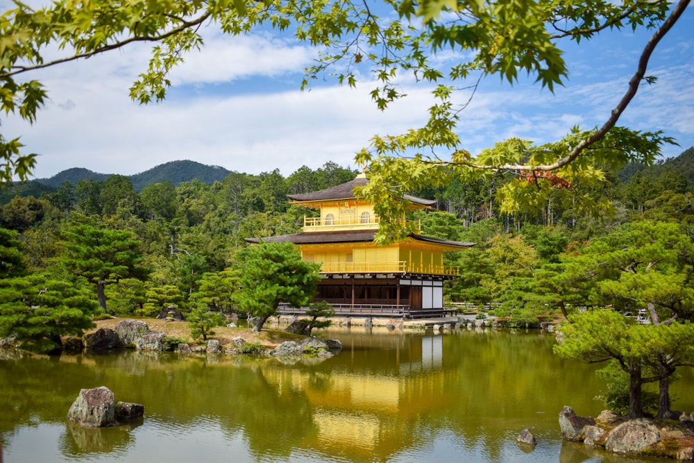 a yellow building in the middle of a pond