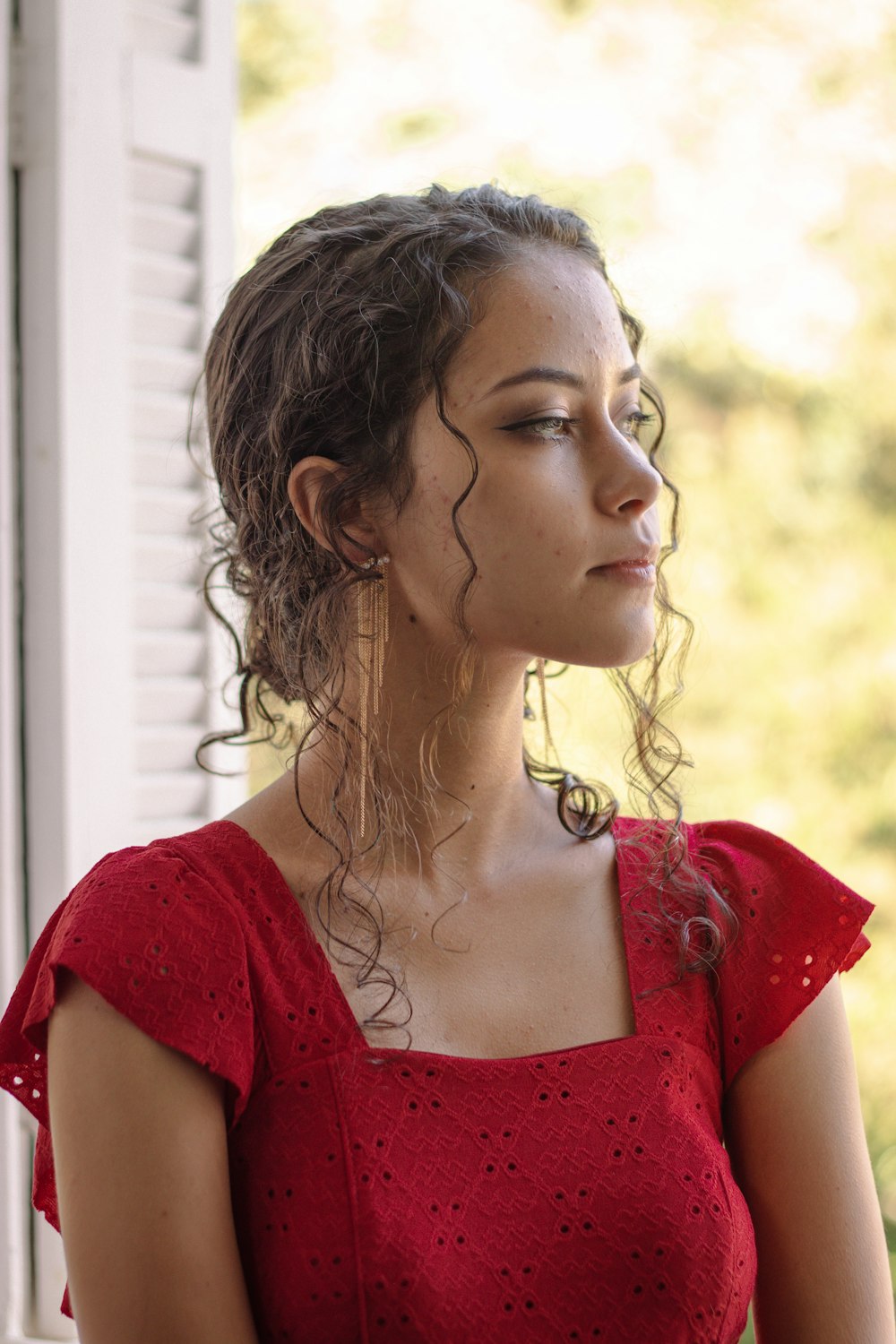 a woman in a red dress looking out a window