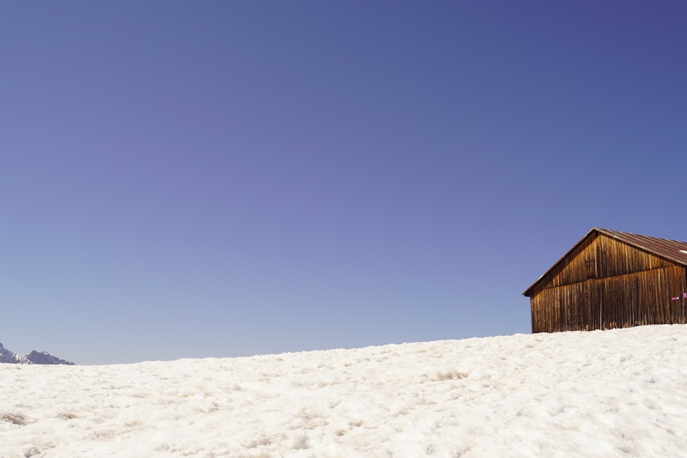 a wooden building sitting on top of a snow covered slope