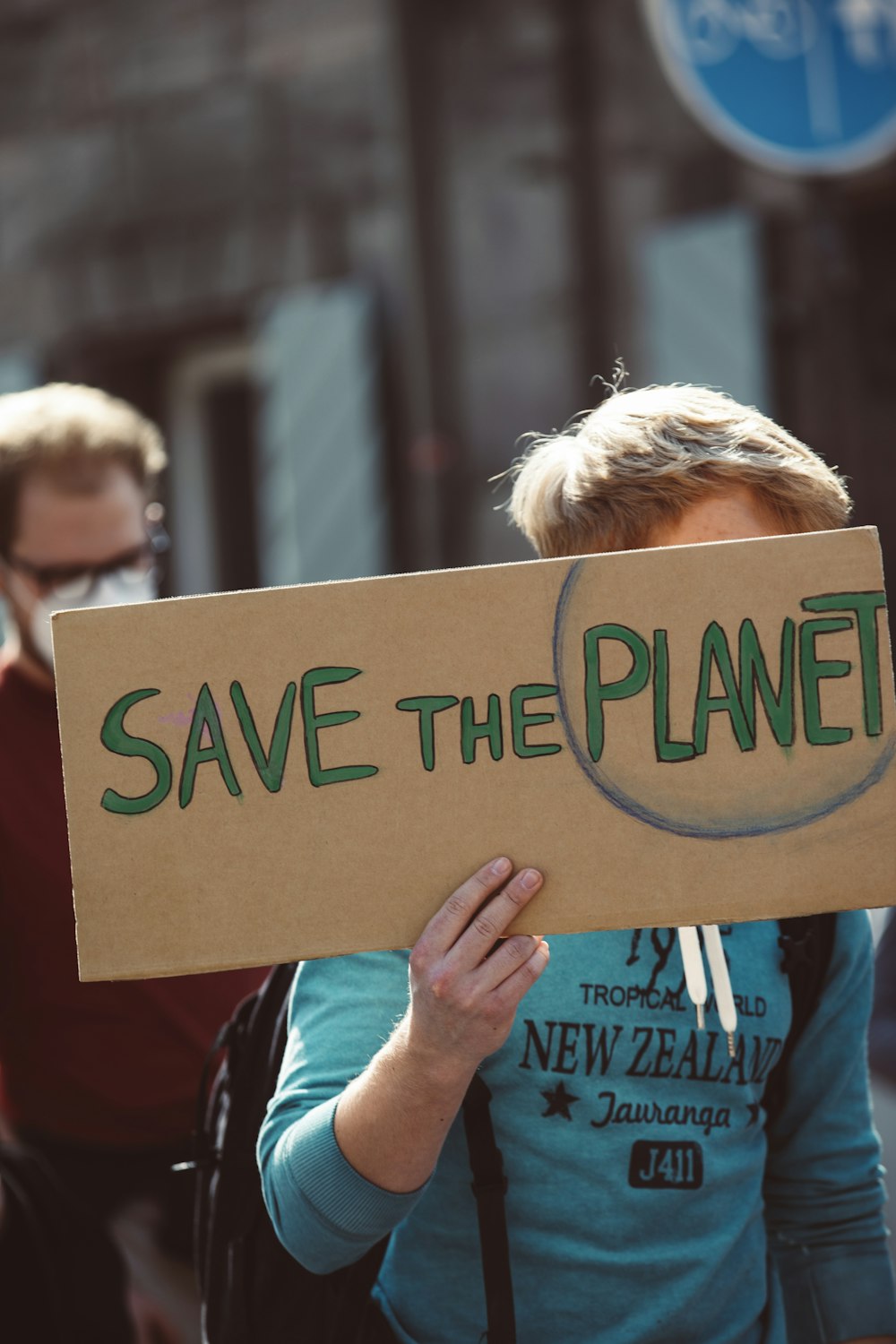 a woman holding a sign that says save the planet