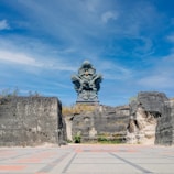 a statue of a person sitting on top of a rock