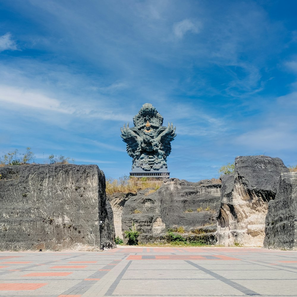 a statue of a person sitting on top of a rock