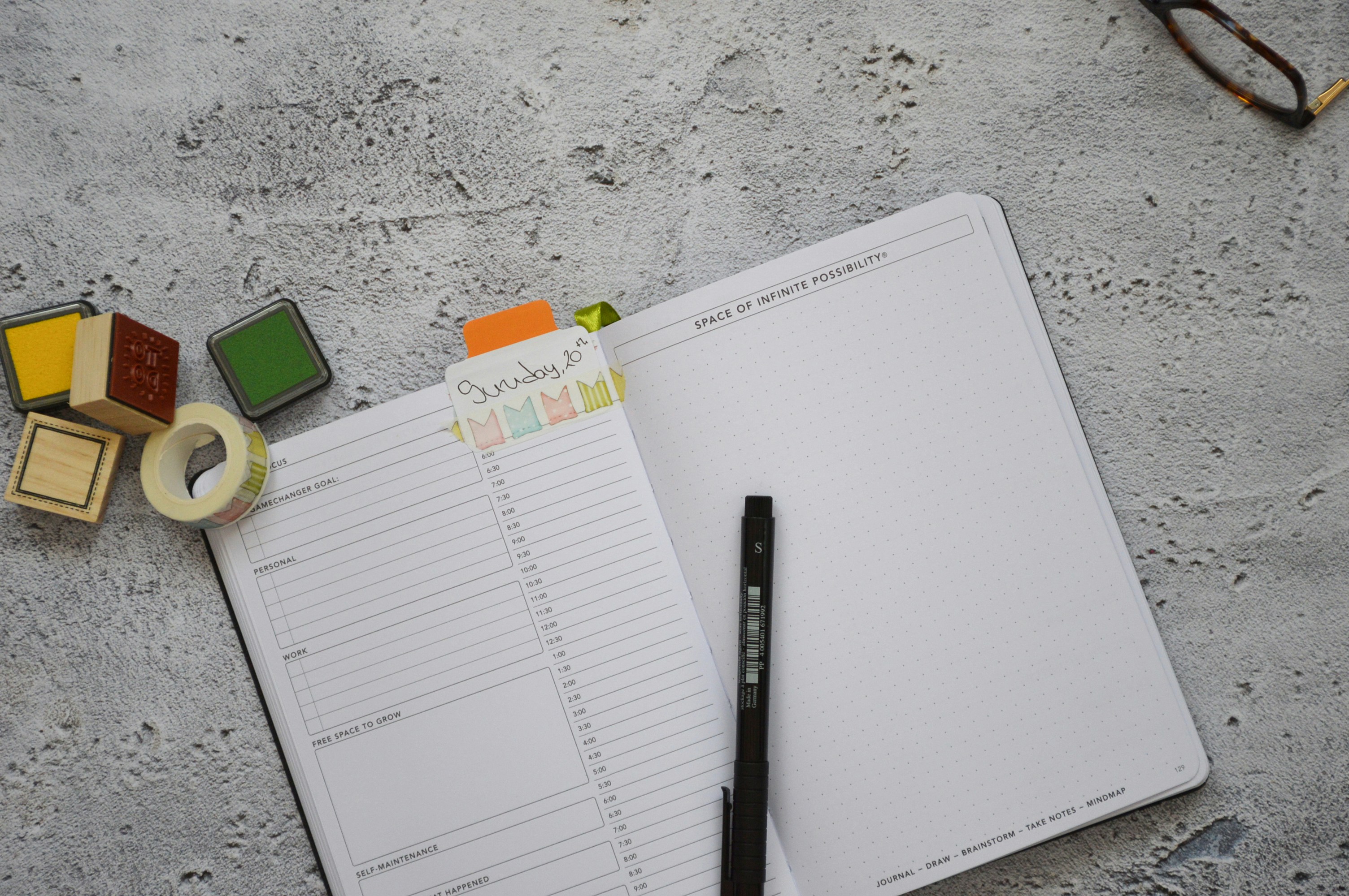 a notepad with a pen and some stamps on it