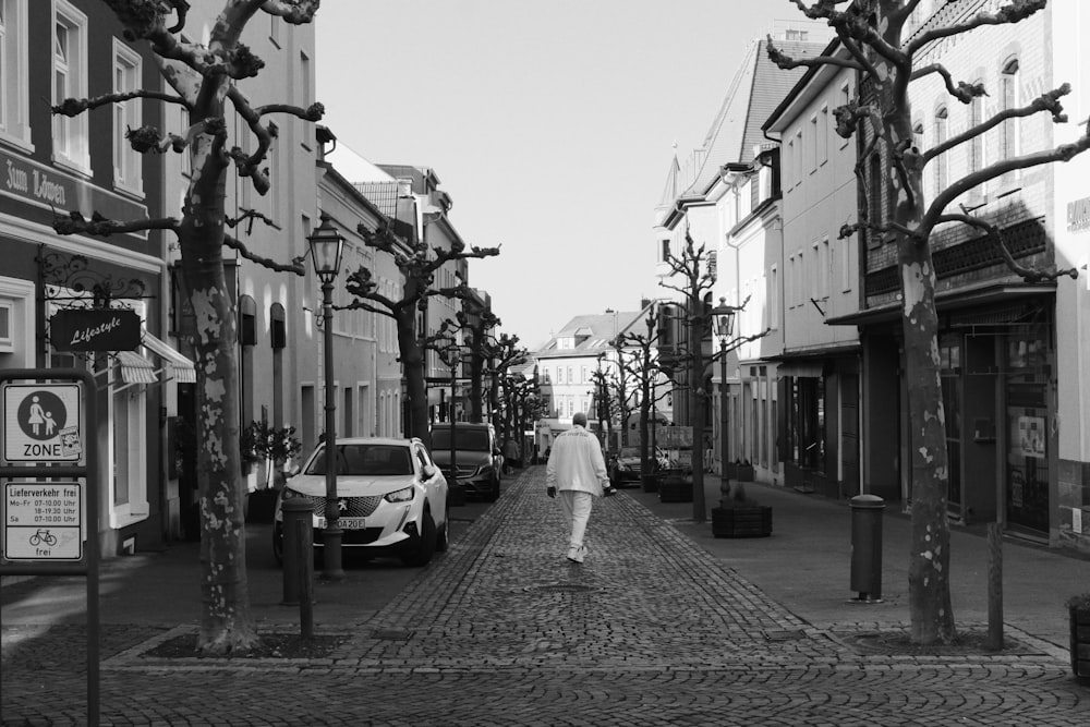 a black and white photo of a person walking down a street